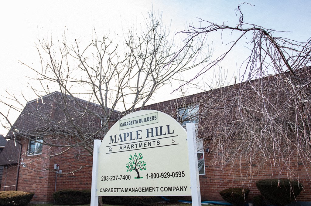 a sign apartments in front of a brick building