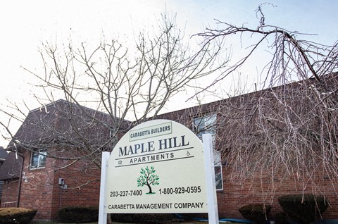 a sign apartments in front of a brick building