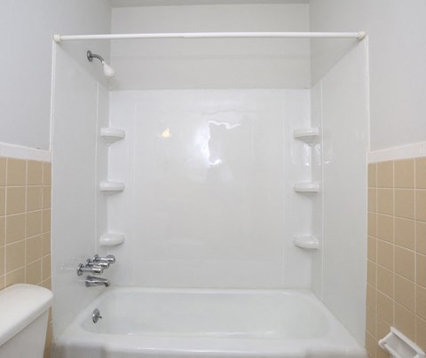 a white bathroom with a tub and a sink