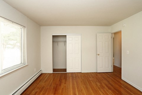 a bedroom with a closet and a window and a door