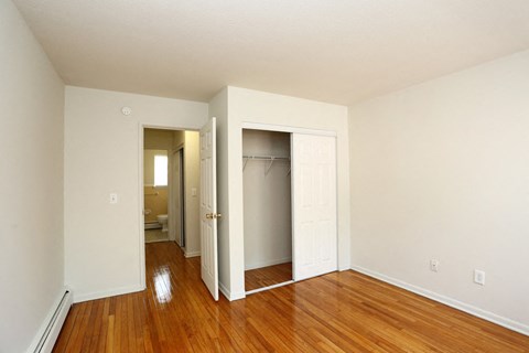 an empty room with wood floors and a closet