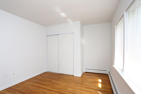 an empty room with a wooden floor and a white door