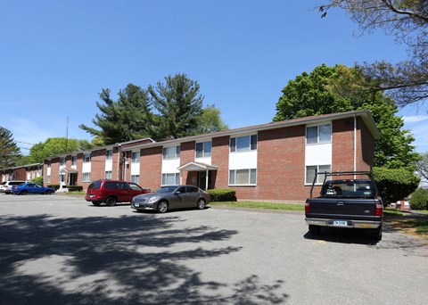 an apartment building with cars parked in a parking lot