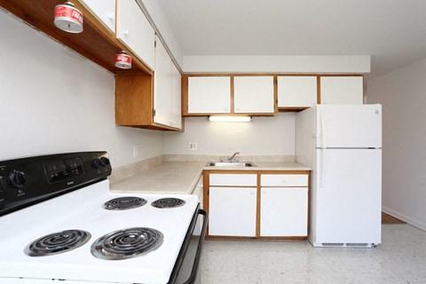 an empty kitchen with a stove and a refrigerator