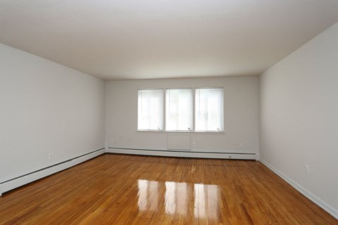 an empty room with wood floors and a window
