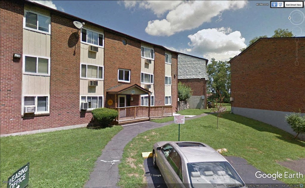 an image of an apartment building with a car parked in front