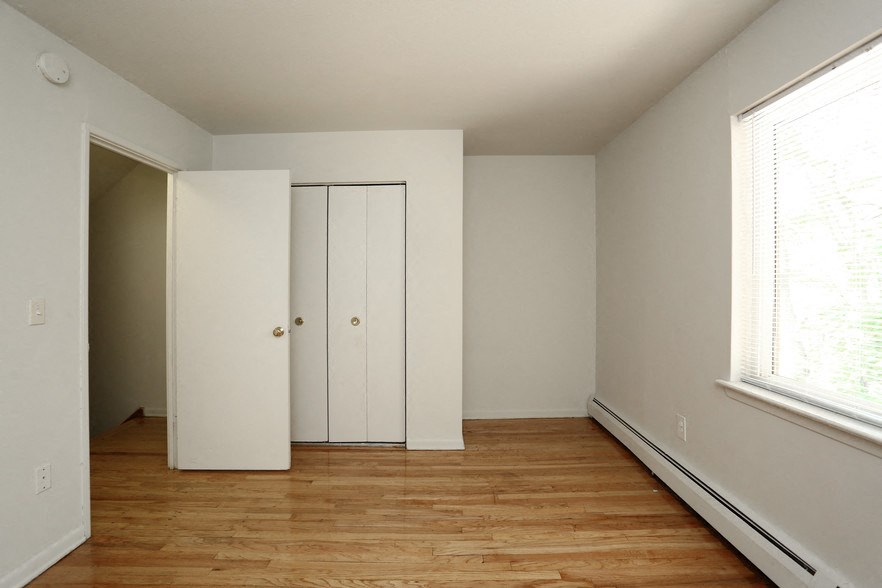an empty room with white walls and a wood floor