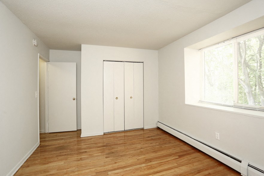an empty room with wood floors and a large window