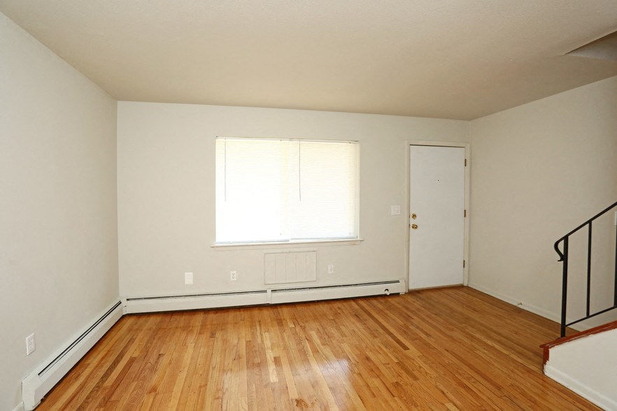 an empty room with a wood floor and a window