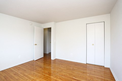 an empty living room with white walls and wood floors