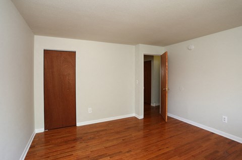 an empty living room with wood floors and a door