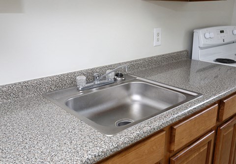a stainless steel sink in a granite kitchen counter top