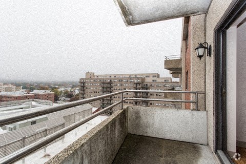 a balcony with a view of a city on a snowy day