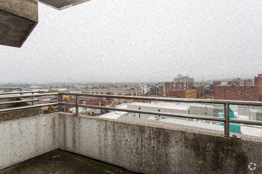 a balcony with a view of a city on a snowy day