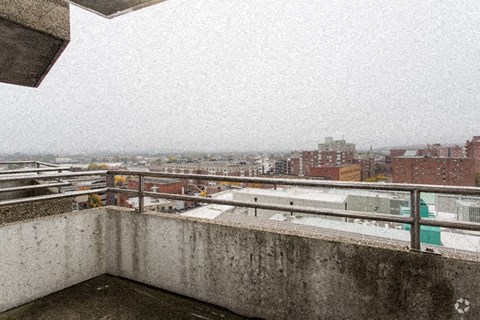 a balcony with a view of a city on a snowy day