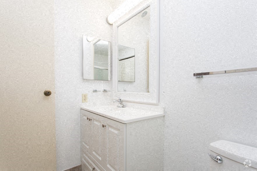 a white bathroom with a sink and a mirror
