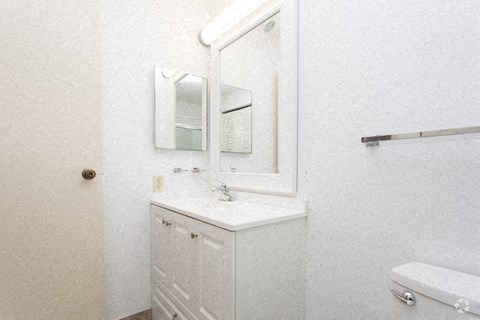 a white bathroom with a sink and a mirror
