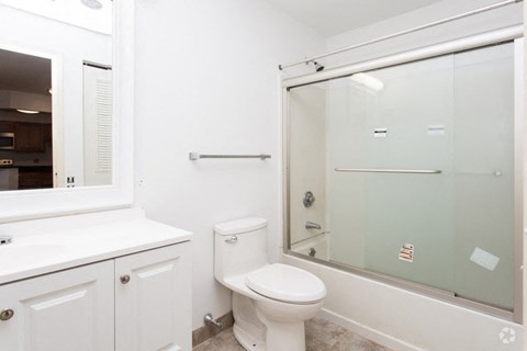 a white bathroom with a shower and a toilet