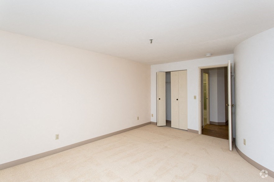 an empty living room with white walls and a door to a hallway