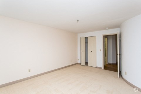 an empty living room with white walls and a door to a hallway