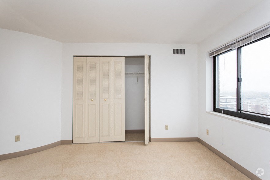an empty living room with a closet and a window