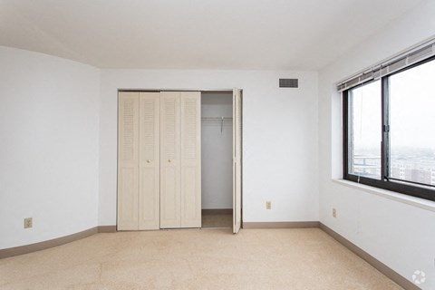 an empty living room with a closet and a window