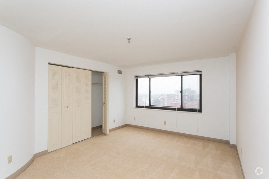 an empty living room with a window and a closet