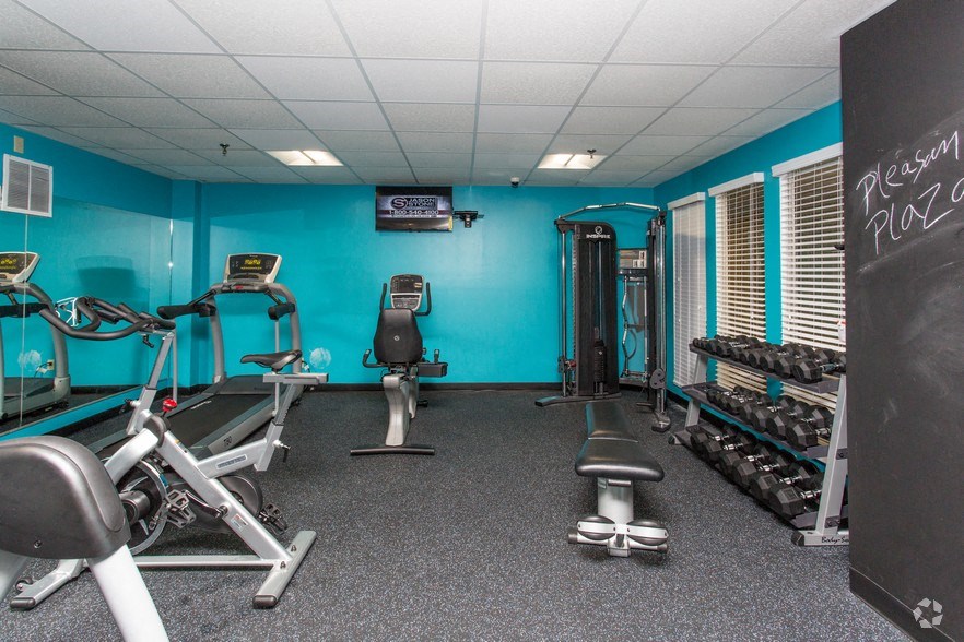 a gym with weights and cardio equipment in a room with a chalkboard