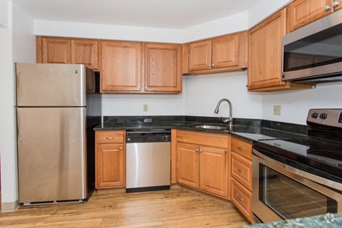 a kitchen with wooden cabinets and stainless steel appliances
