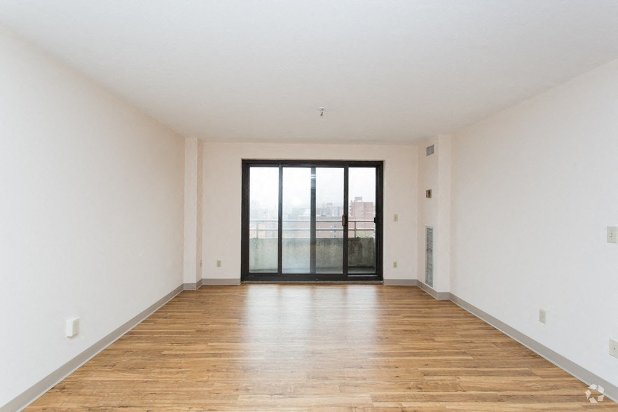 an empty living room with white walls and a sliding glass door