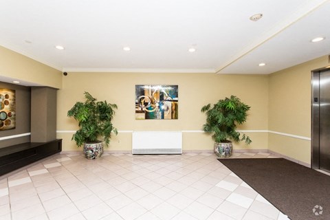 the lobby of a building with two potted plants