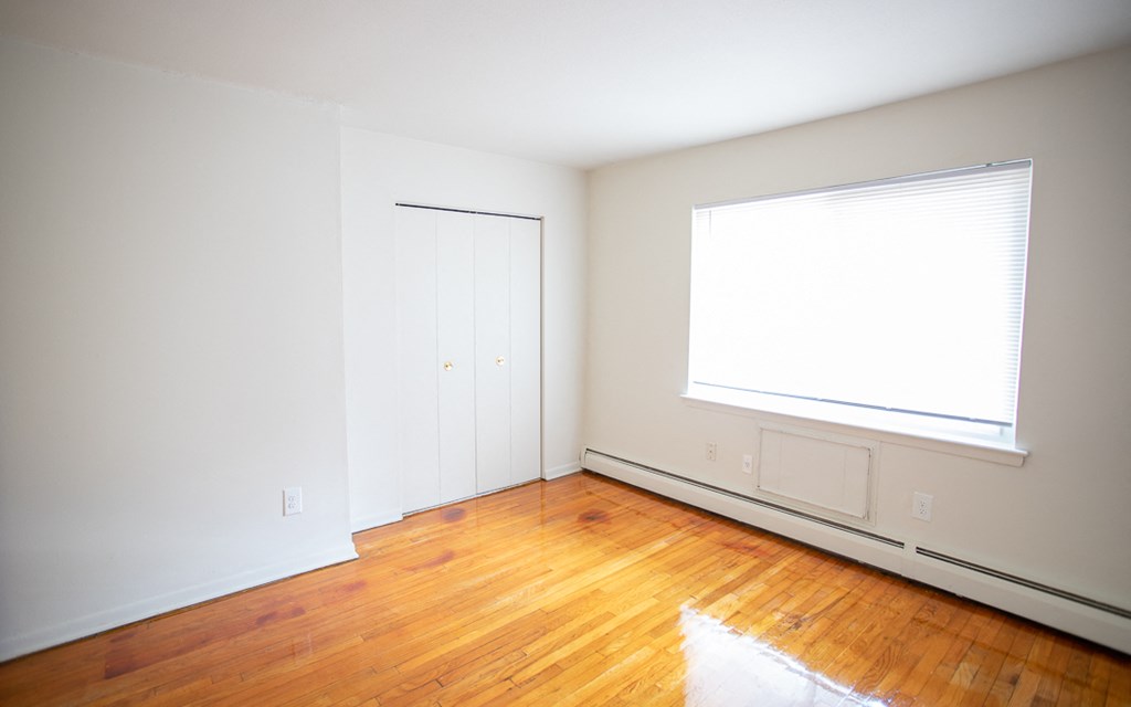 an empty room with wood floors and a window
