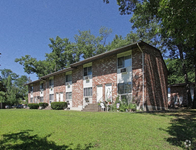 an old brick building with a green lawn
