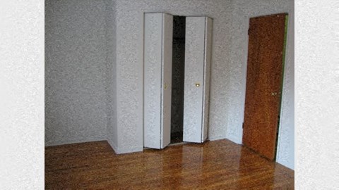 a room with a wooden floor and three doors