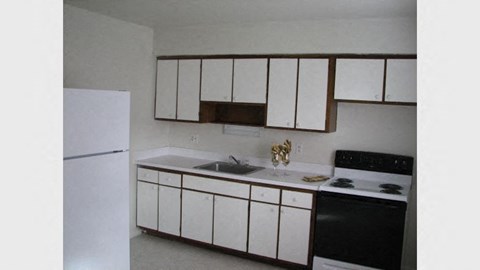 a kitchen with white cabinets and a stove and a refrigerator