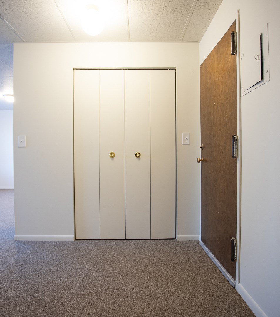an empty room with two closets and a door
