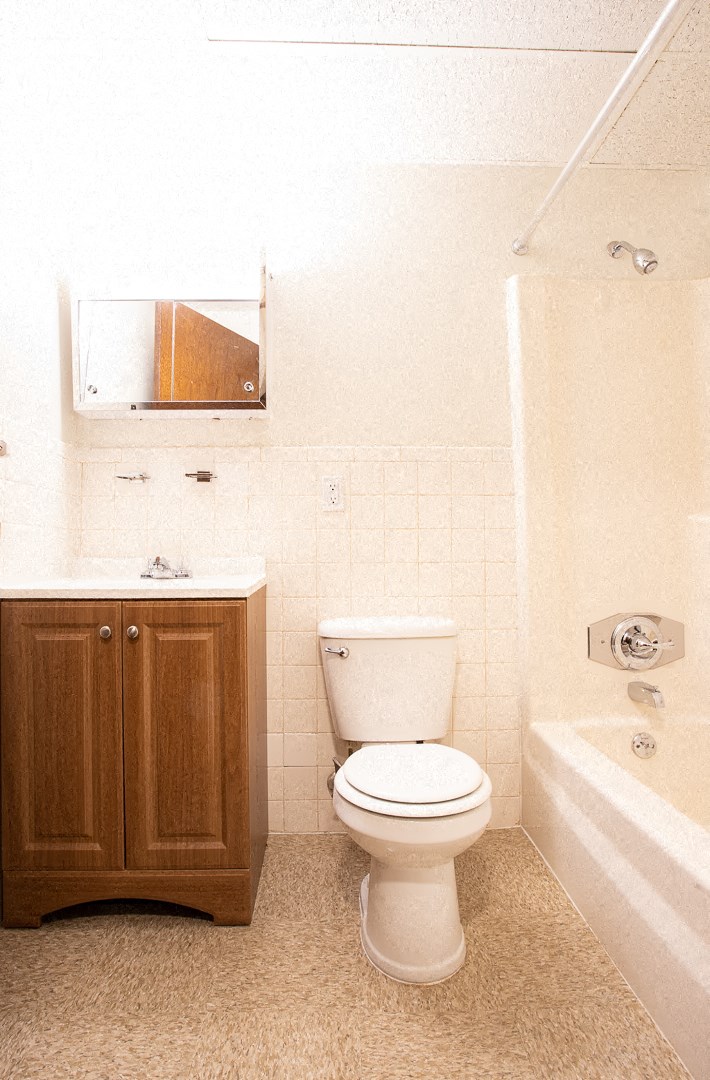 a bathroom with a toilet and a bath tub and a sink