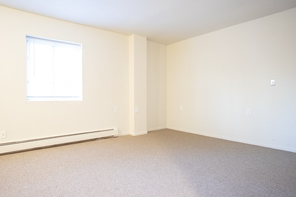 an empty room with carpet and a window
