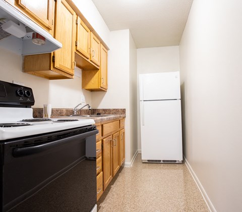 an empty kitchen with a stove refrigerator and sink