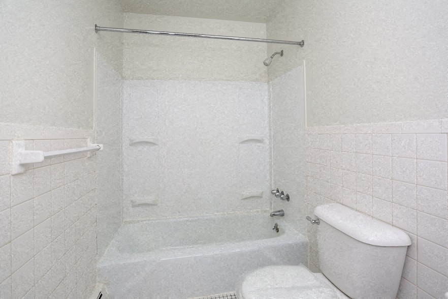 a white bathroom with a shower and a toilet