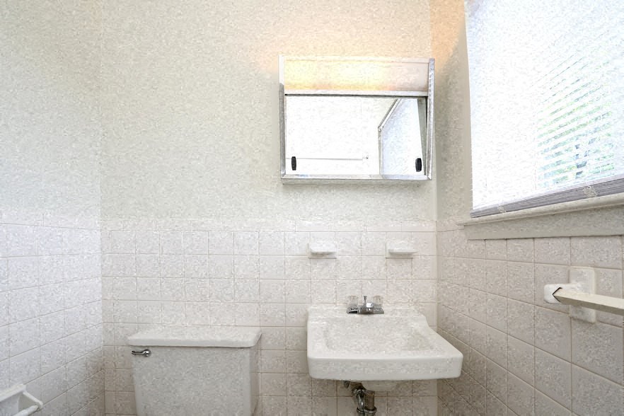 a white bathroom with a sink and a window