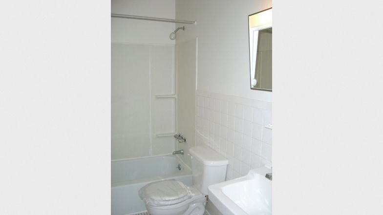 a white bathroom with a toilet and a tub