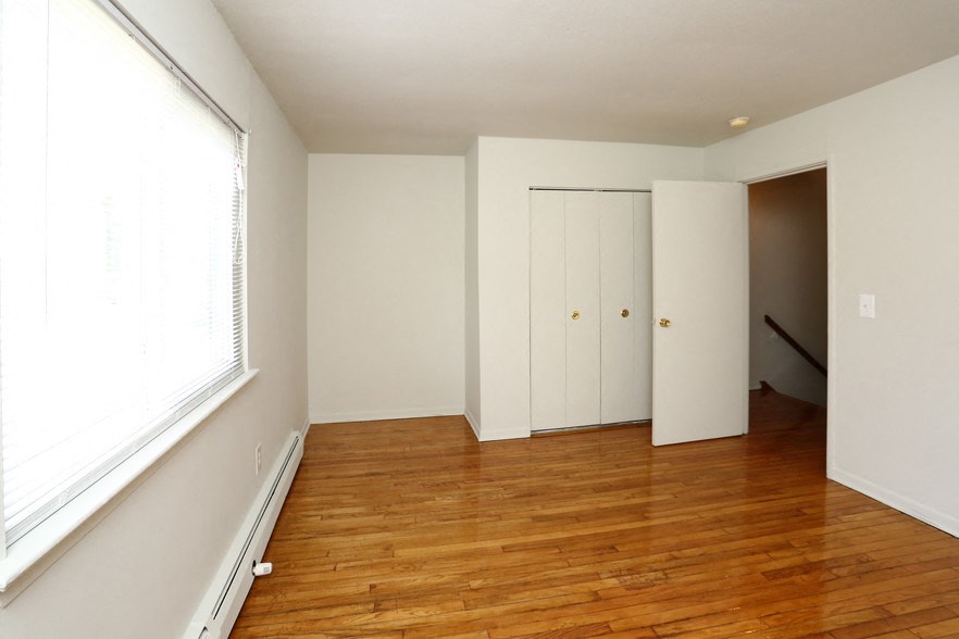 an empty room with a hard wood floor and a large window