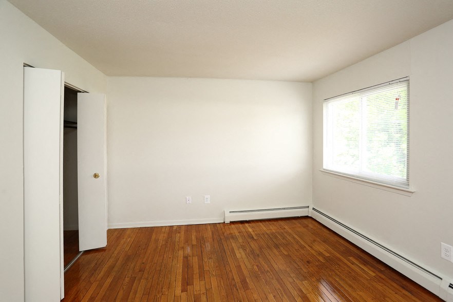 an empty room with wooden floors and a window