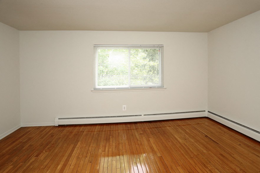 an empty room with wooden floors and a window