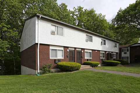 the side of a brick apartment building with a sidewalk