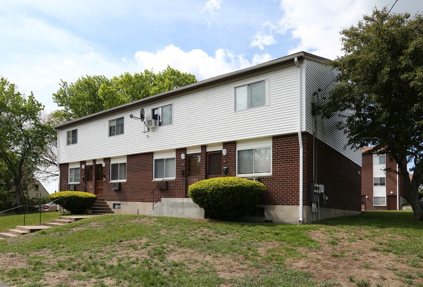 a white and brick apartment building on a hill