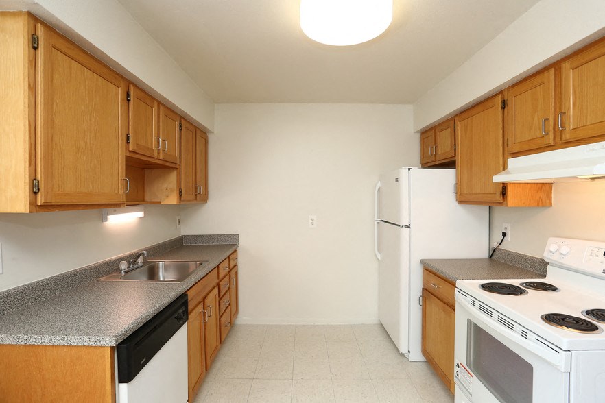 a kitchen with white appliances and wooden cabinets