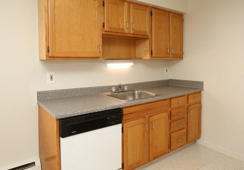 a kitchen with wooden cabinets and a sink and a dishwasher