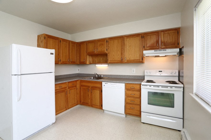 a kitchen with white appliances and wooden cabinets